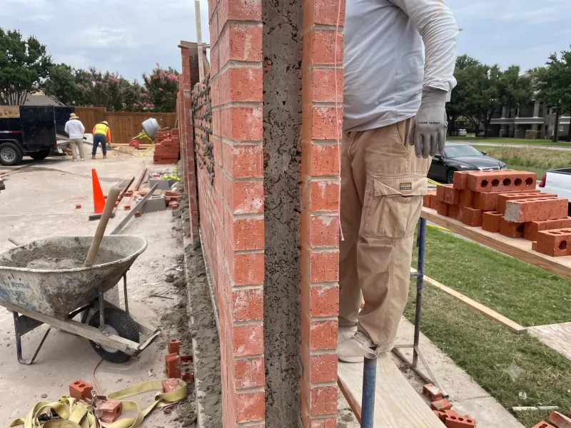 Skilled mason tuck-pointing a historic brick wall